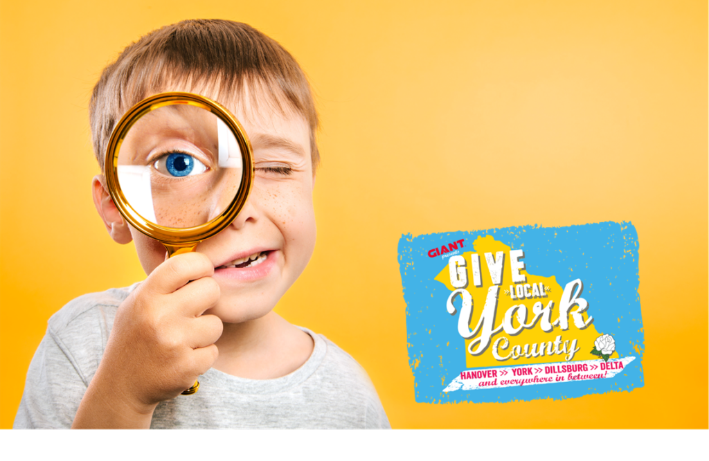 boy with magnifying glass; Give Local York logo